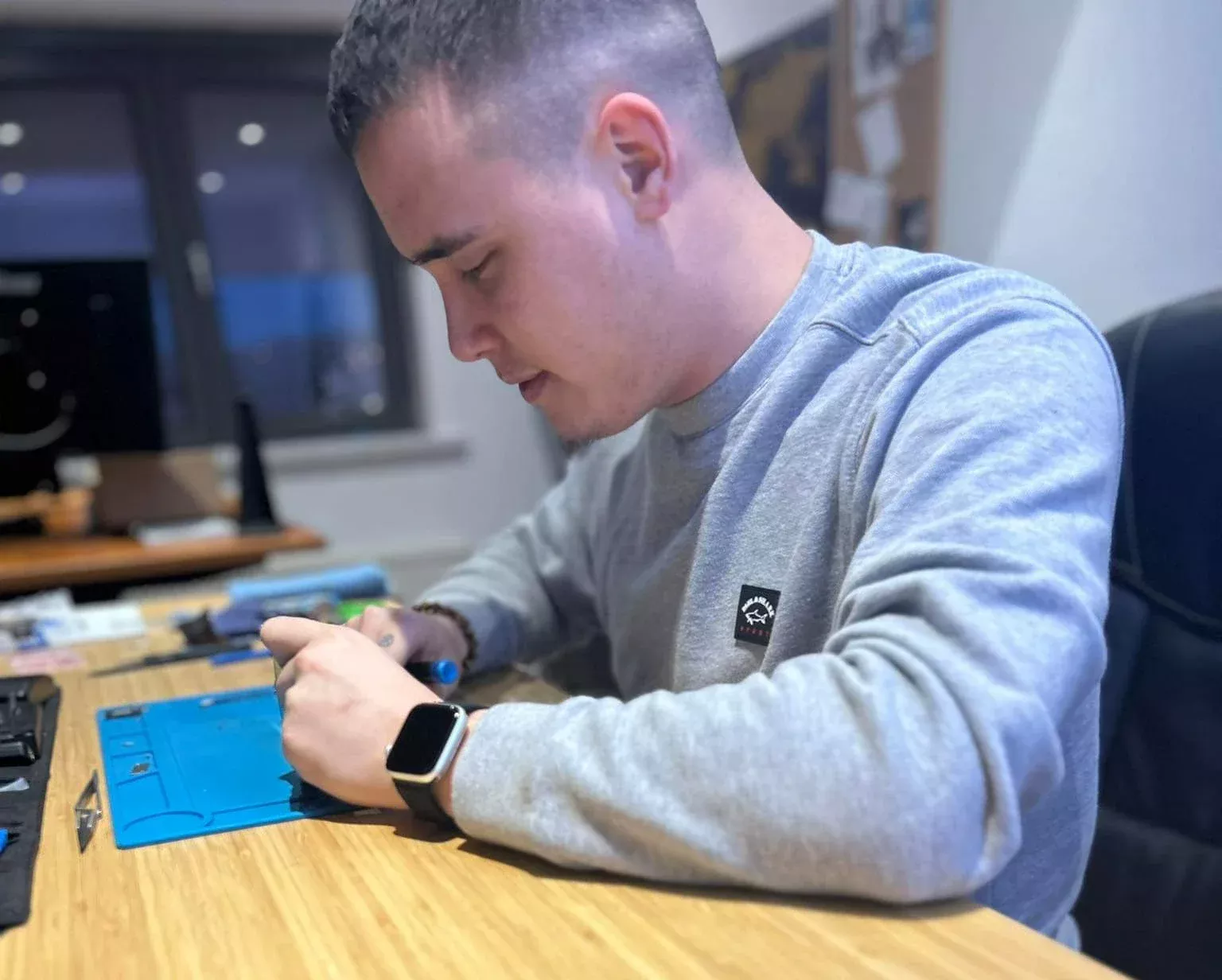 Ben répare un smartphone dans le tout premier bureau de RecoPhone